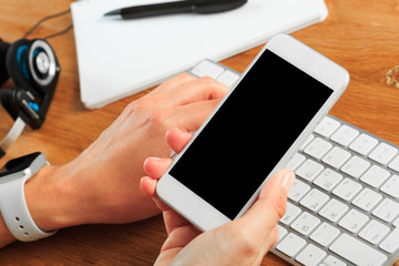 female hands holding smart phone on wooden background  , place for your text  .