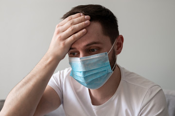 Scared Man in medical mask looks in camera. Scared man in fear of coronavirus stands in protective medical mask against viruses and infections isolated studio. Coronavirus 2019-ncov covid-19 concept.