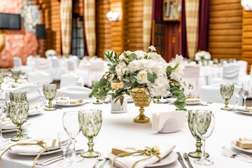 White wedding decoration in restaurant. Luxury wedding arrangement. Wedding banquet decoration. Tables in restaurant decorated with beautiful white peonies and roses