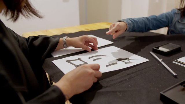 woman writing Japanese calligraphy discussion