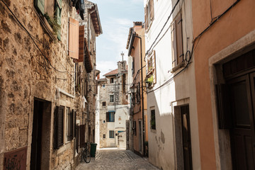 Fototapeta na wymiar Travel summer concept. Old city view of Europe, Croatia, Istria region, Rovinj. Empty street with old buildings with shutters. Horizontal photo.