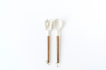 Salad serving utensils set. Wooden spoon and fork on white background. Minimal kitchenware concept.