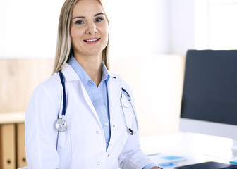 Woman doctor standing in hospital office. Physician at work, life portrait. Medicine and health care concept