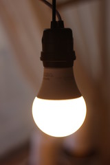 Foco ahorrador, de luz cálida, encendido y colgado