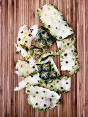 Preparing a whole pineapple in the kitchen. Fresh and ripe fruit preparation. Ingredients for homemade pineapple salsa. On a wood chopping board with knife. Closeup view. Organic sweet fruit