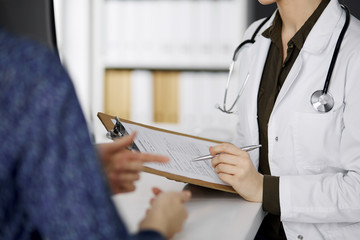 Doctor and patient discussing current health examination while sitting in clinic. Perfect medical...