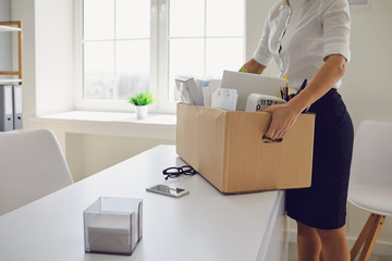 Unemployment Dismissed businesswoman upset with a cardboard box leaves the workplace from the...