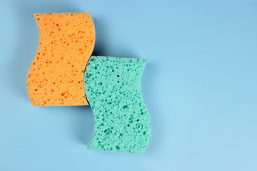 Two bath sponges on a blue background, copy space