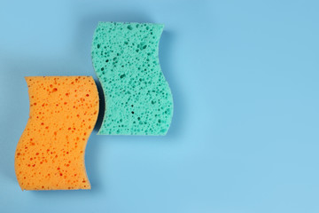 Two bath sponges on a blue background, copy space