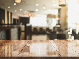 Empty wooden top table in front of abstract blurred beverage bar. Mock up for display of product