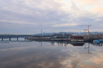 Fototapeta na wymiar View of the Dnieper river and construction cranes on right bank in Kiev, Ukraine