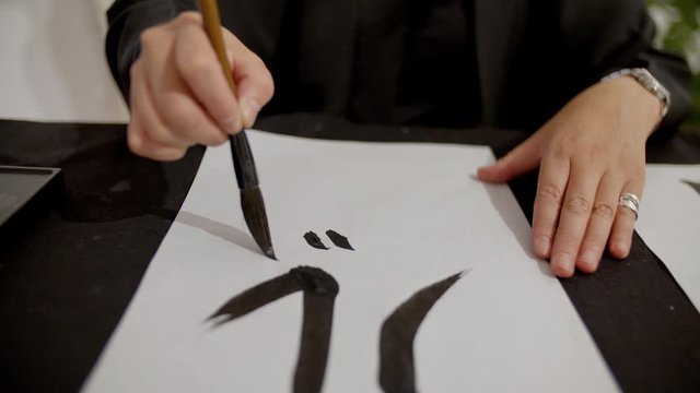 woman writing Japanese calligraphy slowmotion