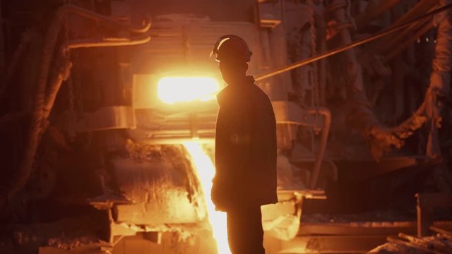 Hard work in a foundry. Metal smelting furnace in steel mill. Molten metal pouring, metallurgy, steel casting foundry. Steel manufacturing