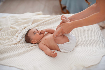 Baby massage. Woman does gymnastics for the baby for its development.