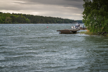 a river bend with pontoons and a white boat at one; cloudy day