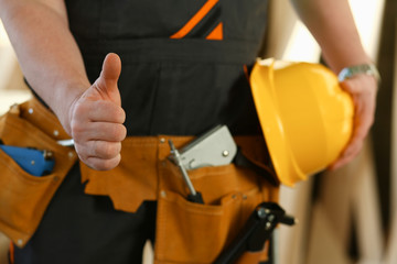 Hand of worker in yellow helmet show confirm sign with thumb up at arm portrait. Manual job DIY inspiration joinery startup idea fix shop hard hat industrial education profession career concept