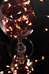 wine glass with fairy lights inside and lights around with a dark background creating a bokeh