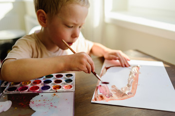 Child drawing in watercolor very enthusiastically