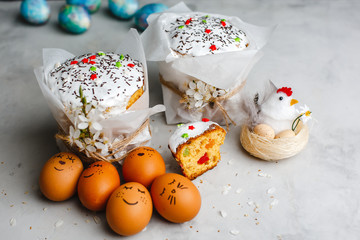 Glazed Easter cake decorated with colorful sprinkles. Complex decor of painted eggs and cherry blossoms. Top view, side view. Space for text.