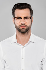 Fototapeta premium bearded man in glasses looking at camera isolated on grey