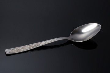 table spoon on black glass