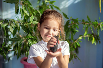 A girl in a white T-shirt holds a Mongolian gerbil in her hands and hugs her. Children and animals