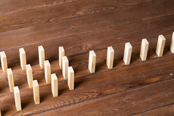 Rows of dominoes standing on wooden table