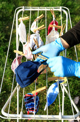 Hygienic mask hanging on the rack outdoor after being washed for cleanness and hygiene during Covid-19 virus outbreak. Drying mask hanging under the sun after use for disinfecting.