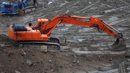 Tractors and excavators work on the construction of the foundation zero cycle