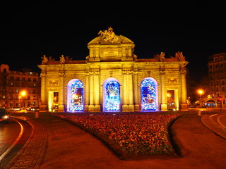 Puerta de Alcalá, monumento en el centro de Madrid, iluminado por la noche con luces de Navidad.