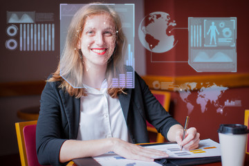 Portrait of young Caucasian businesswoman working with document. Self-employed female auditor working in cafe and smiling at camera through face scan virtual infographics. Woman in business concept