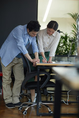 Two busy colleagues working at the table with documents at office