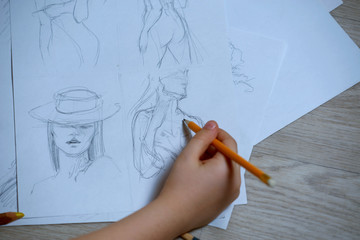Sketches, sketching on white paper with a simple pencil. Colour pencils