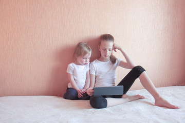 Obraz premium Two girls on the couch with a laptop