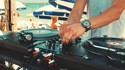 Dj plays music at the beach party on a sunny summer day