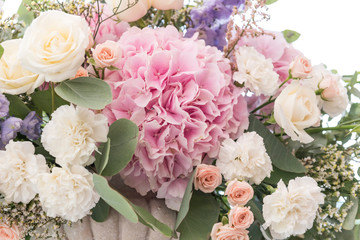 Wedding bouquet of different flowers; pinl, lilac, white roses. Wedding arrengement. Preparation of wedding ceremony in suburbun restaurant