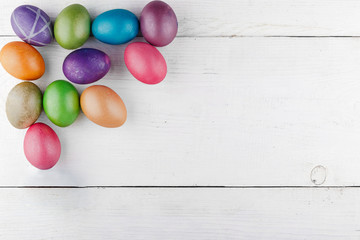 Fototapeta na wymiar Easter eggs on the left on a white wooden background