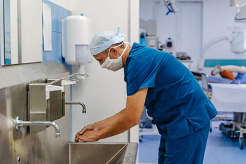 Doctor disinfects hands. Medical specialist washes hands. Surgery.