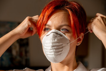 face of young woman in putting on face mask