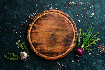 Food background. Kitchen board on the table with spices and herbs. Top view.