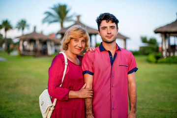 old mother and adult son for a walk in the summer