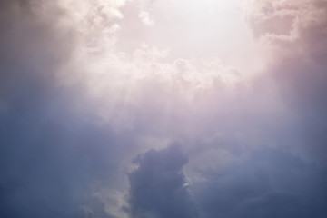 Rays of sunlight break through the dense cloudy sky