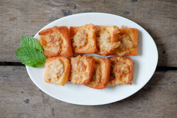 Fried Bread with Minced Pork Spread on a plate, placed on a wooden floor