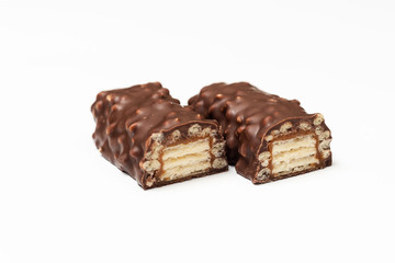 sliced chocolate bar with dark brown chocolate with nuts on a white background.