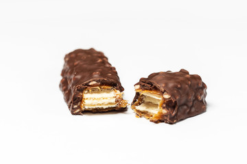 Broken chocolate bar with dark brown chocolate with nuts on a white background.