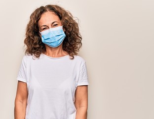 Middle age woman wearing coronavirus protection mask for covid-19 epidemic virus with a happy and...