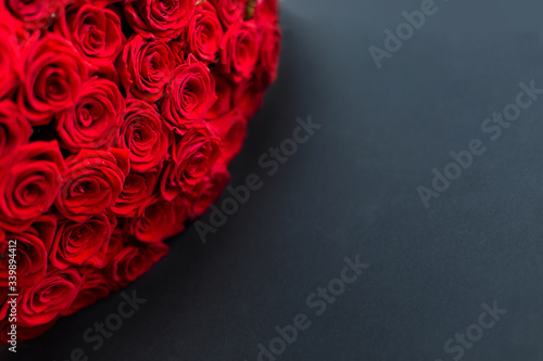 red roses black background banner. Bouquet of flowers. Florist shop postcard. Space for text copy space. Anniversary celebration. February 14 is Valentine's Day. March 8 Mother's Day dark contrast