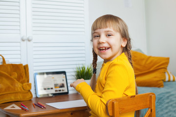 Kids and distance learning concept. HappLittle girl learning at home. Distance learning and on-line education concepty smiling school girl and boy on blackboard background