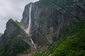 Pissing Mare Falls plunging into Western Brook Pond with steep rock cliff at Gros Morne National Park Newfoundland