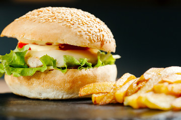 Chiken burger with tomatos and fries. Junk food. Fastfood. Bodypositive. Food on quarantine from delivery. Photo for menu.